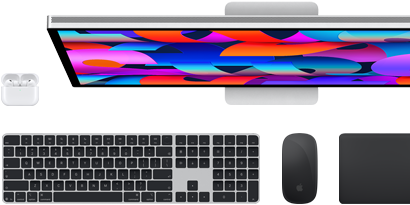 En samling tillbehör och enheter: AirPods, Magic Keyboard med Touch ID, Magic Mouse, Magic Trackpad och Studio Display