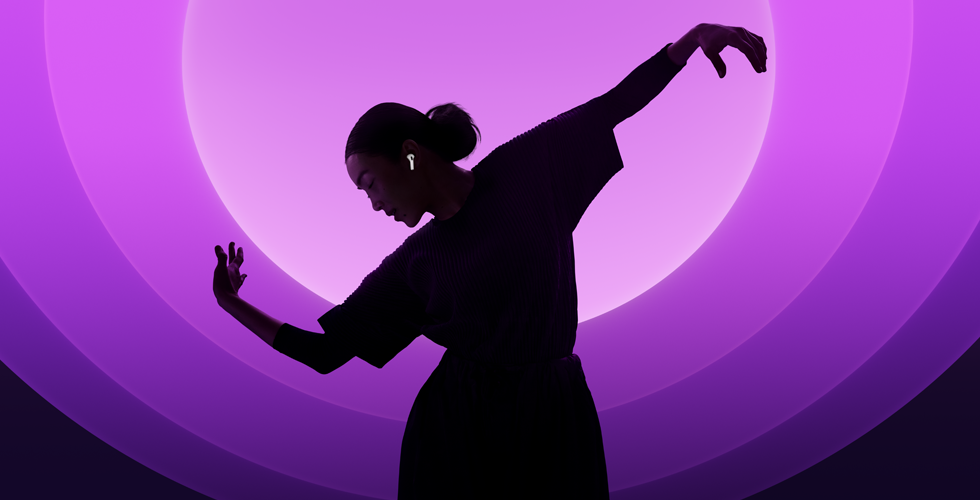En person som dansar med AirPods 5 i öronen mot en bakgrund i olika färger