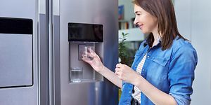 MDA-Fridges-Fridge with ice machine-Woman getting ice in glass from the fridge